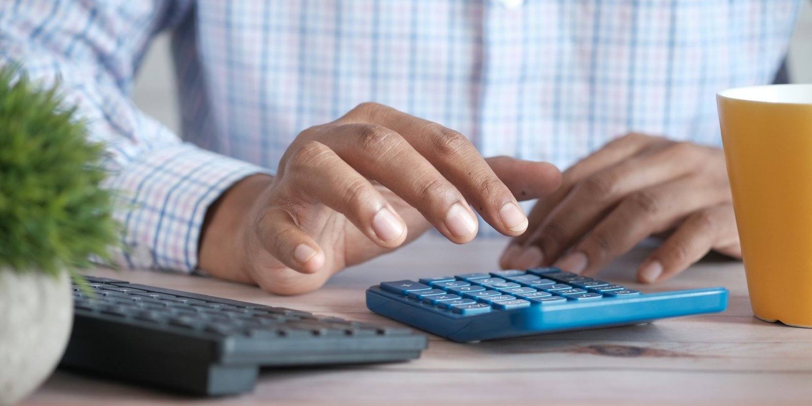 Man Typing On Calculator Financing-1600x800